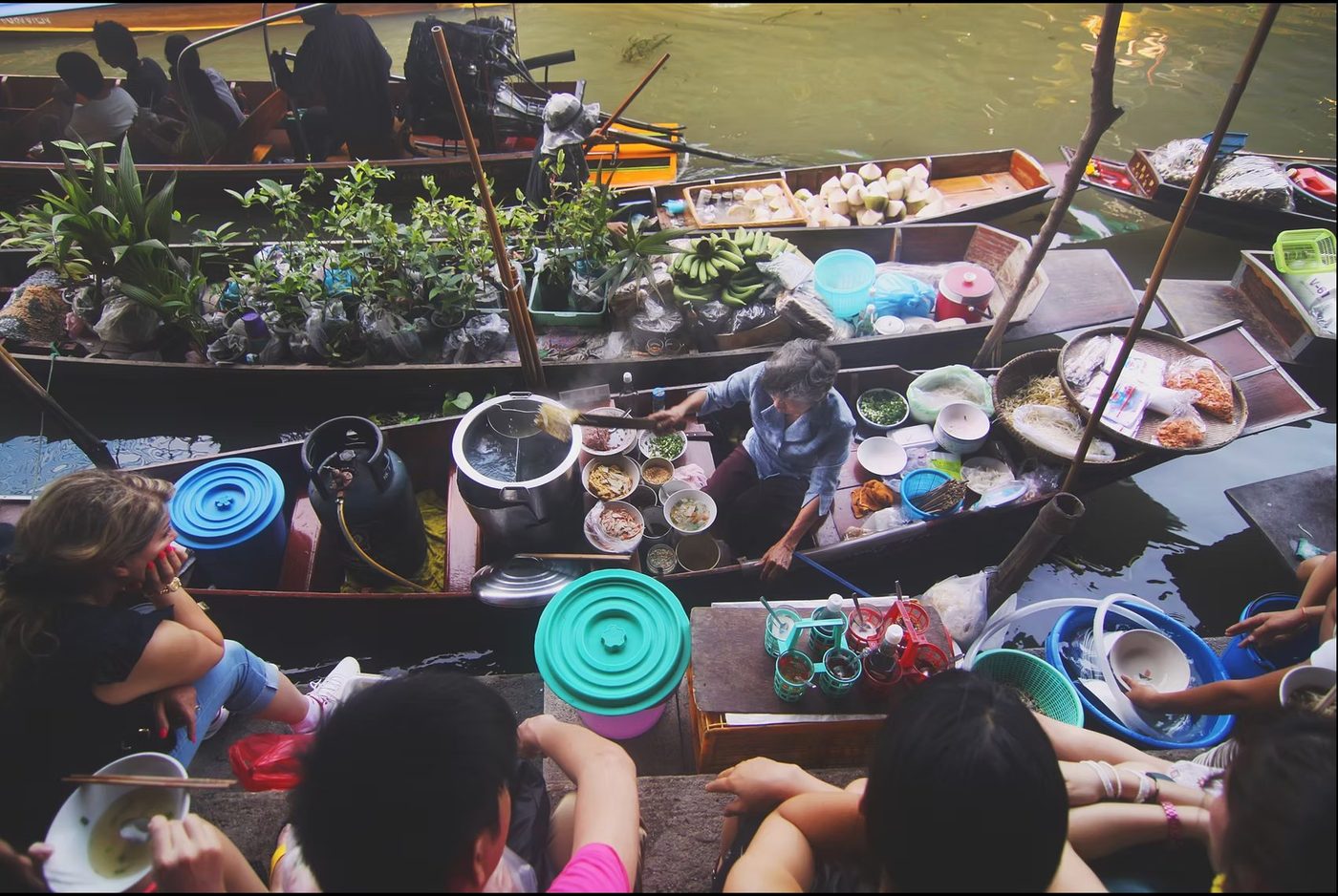 Thai floating market vendor cooking on a boat